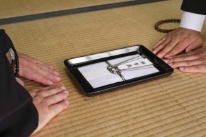お布施を切手盆でお坊さんに渡す様子